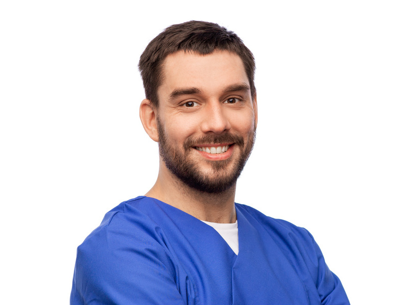healthcare, profession and medicine concept - happy smiling doctor or male nurse in blue uniform with crossed arms over white background